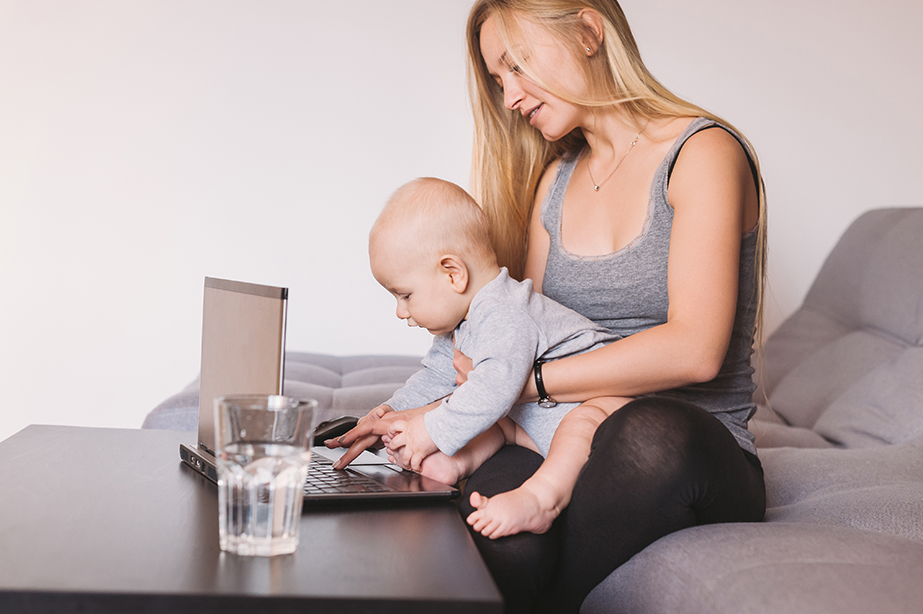 matka z dzieckiem przy laptopie i szklance wody